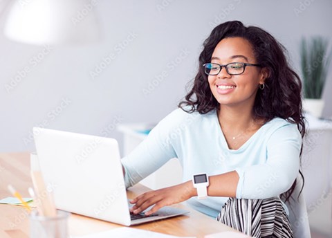 A woman sitting at a table with a laptop.