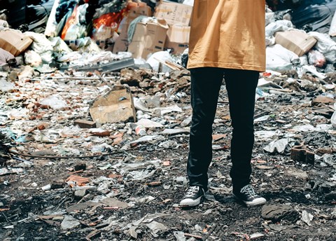 A person standing in a pile of trash.