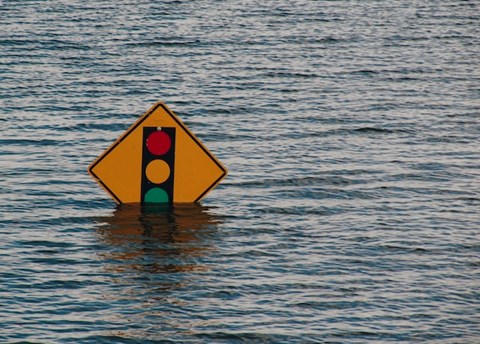 A yellow and green sign in the water.