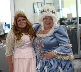 A person in a garment next to a person in a dress.