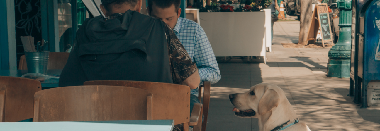 A person and a dog sitting at a table.