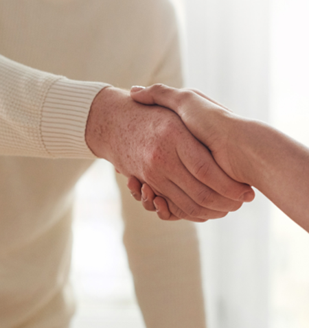 A close-up of a man shaking hands with a woman.