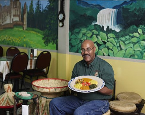 A person sitting at a table with a plate of food.