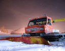 A red truck on a snowy road.