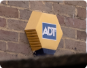 A yellow and blue box on a brick wall.