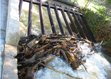 A pile of wood next to a water fall.