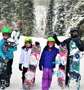 A group of snowboarders pose for a photo.