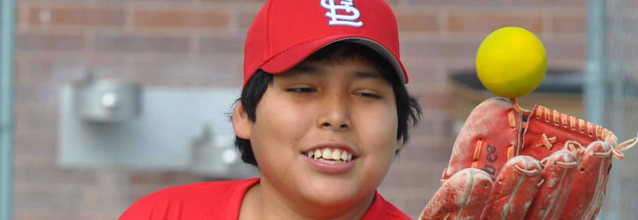 A young boy holding a baseball.