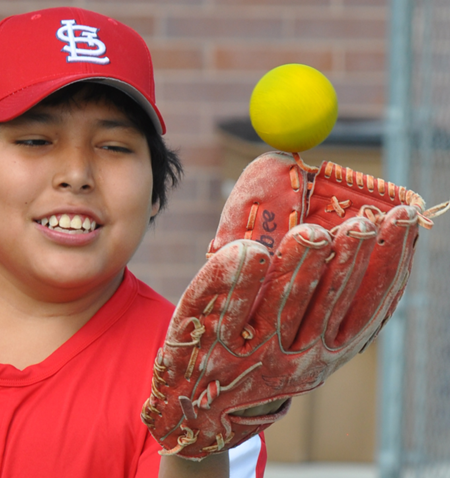 A young boy holding a baseball.