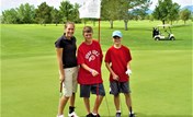 A group of men posing for a picture on a golf course.